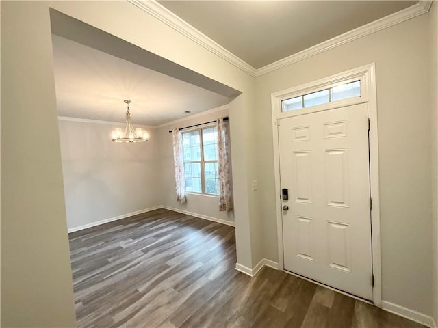 foyer entrance featuring dark wood-type flooring, ornamental molding, and a chandelier