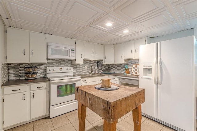7234 Post Rd, Winston, GA 30187 - kitchen featuring white appliances, light tile patterned flooring, an ornate ceiling, decorative backsplash, and white cabinets