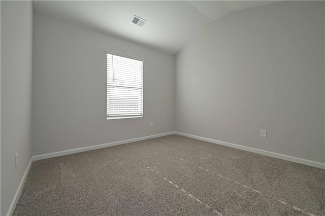 spare room with carpet flooring and lofted ceiling