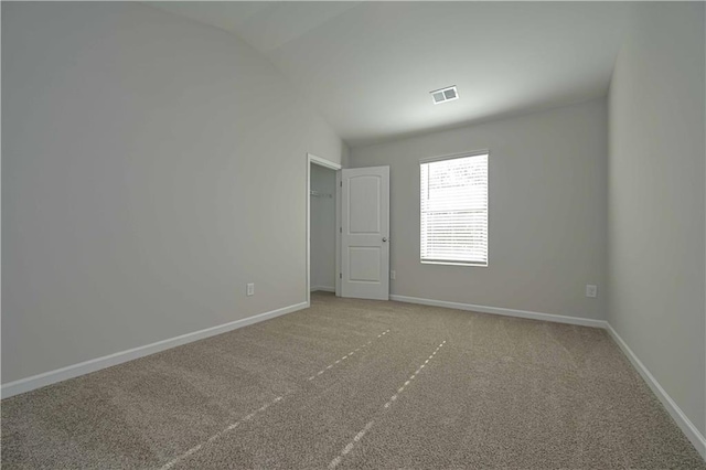 empty room with carpet and lofted ceiling