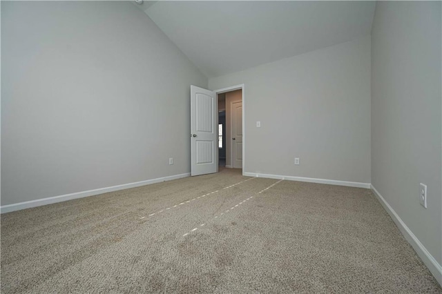 carpeted spare room featuring high vaulted ceiling