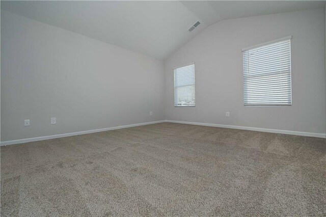 empty room with light carpet and vaulted ceiling