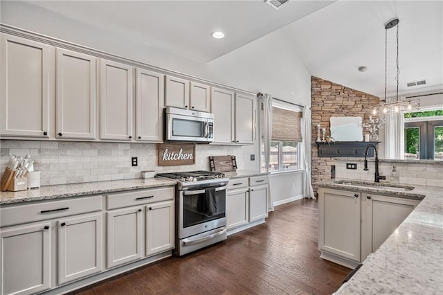 217 Springs Xing, Canton, GA 30114 - kitchen with stainless steel appliances, lofted ceiling, backsplash, pendant lighting, and light stone counters