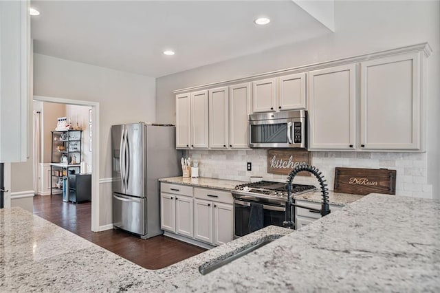 217 Springs Xing, Canton, GA 30114 - kitchen with appliances with stainless steel finishes, light stone counters, backsplash, dark wood-style flooring, and white cabinetry