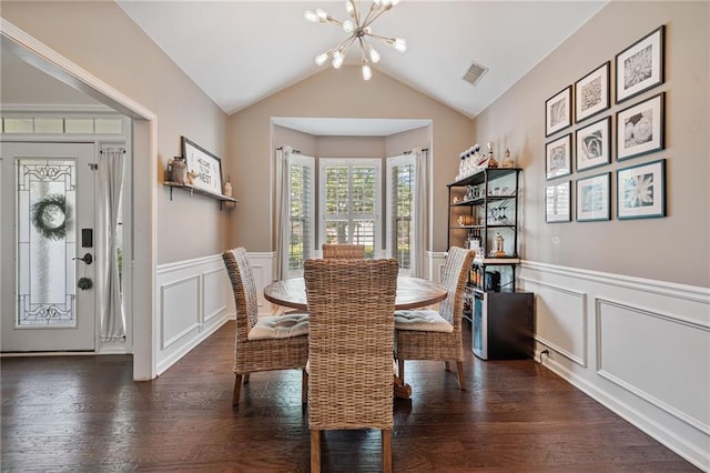 217 Springs Xing, Canton, GA 30114 - dining space with a chandelier, a decorative wall, wood finished floors, lofted ceiling, and wainscoting