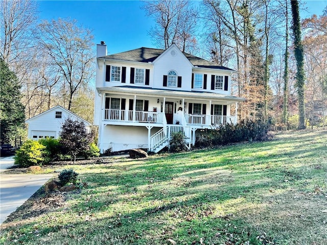 view of front of home featuring an outbuilding, a porch, a garage, and a front lawn