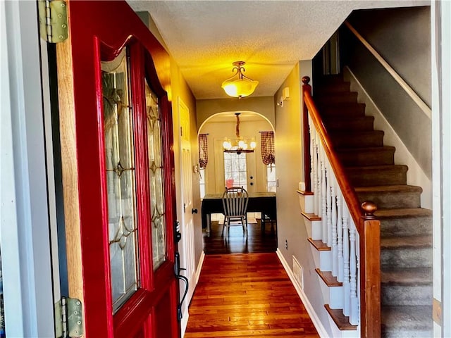 entryway featuring dark hardwood / wood-style floors, a textured ceiling, and an inviting chandelier