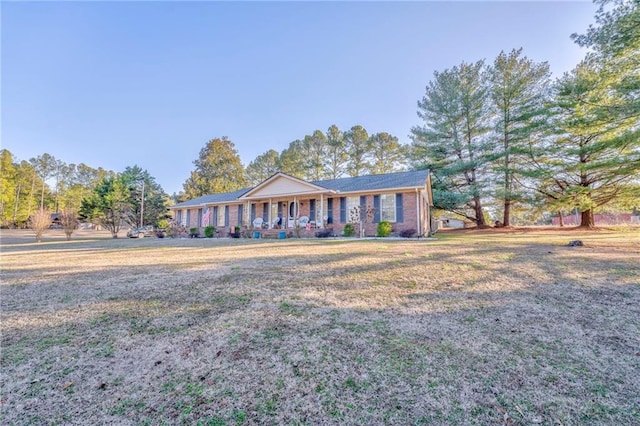 ranch-style home featuring a porch and a front yard