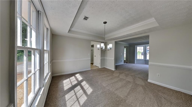 unfurnished dining area featuring a chandelier, a raised ceiling, carpet flooring, a textured ceiling, and baseboards