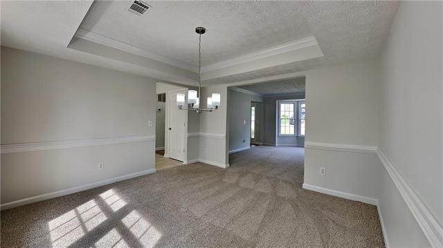 unfurnished dining area with a chandelier, a tray ceiling, carpet, a textured ceiling, and ornamental molding