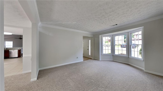 unfurnished room with light colored carpet, crown molding, a textured ceiling, baseboards, and ceiling fan