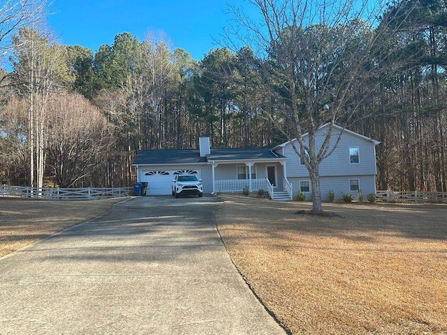 view of front of property featuring a porch, a garage, and a front lawn