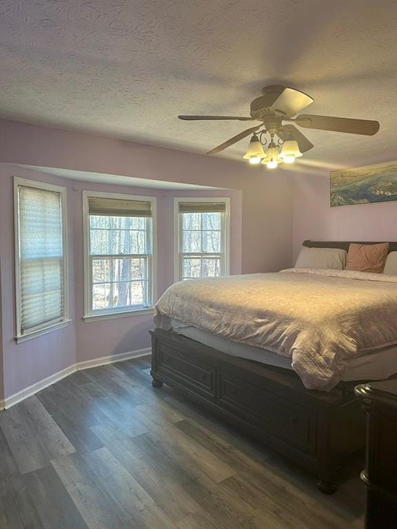 bedroom featuring a textured ceiling, ceiling fan, and dark hardwood / wood-style floors