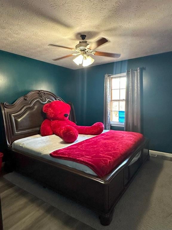 bedroom featuring hardwood / wood-style floors, ceiling fan, and a textured ceiling