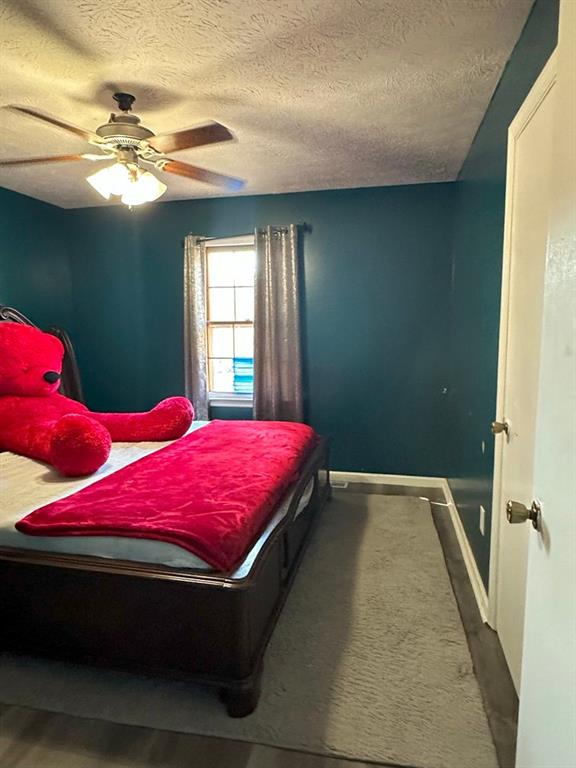 bedroom featuring a textured ceiling and ceiling fan