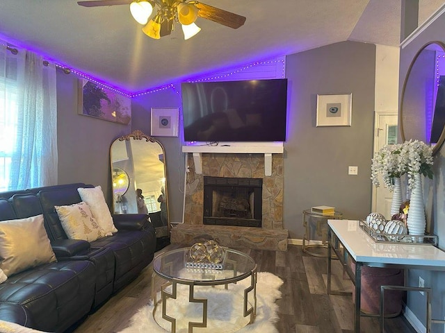 living room with a fireplace, hardwood / wood-style flooring, vaulted ceiling, and ceiling fan