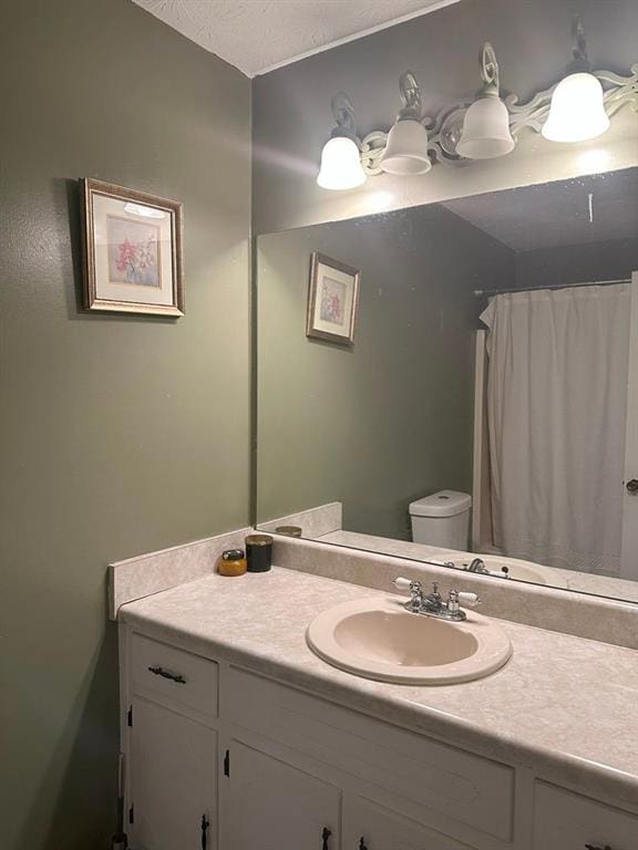 bathroom featuring vanity, toilet, and a textured ceiling