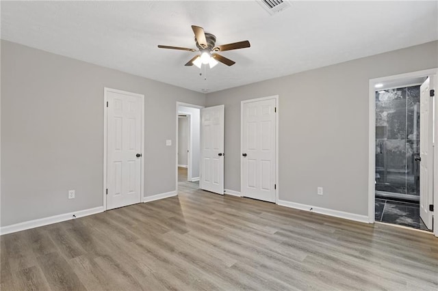 2310 Whitehead Place Dr, Suwanee, GA 30024 - unfurnished bedroom with wood finished floors, connected bathroom, and a ceiling fan