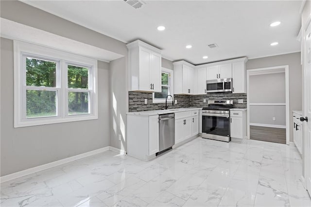2310 Whitehead Place Dr, Suwanee, GA 30024 - kitchen featuring appliances with stainless steel finishes, healthy amount of natural light, backsplash, white cabinetry, and recessed lighting