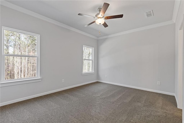 spare room featuring baseboards, visible vents, a ceiling fan, dark carpet, and crown molding