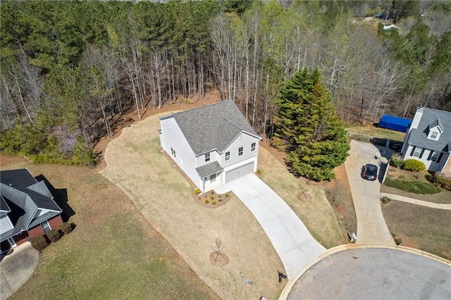birds eye view of property with a view of trees