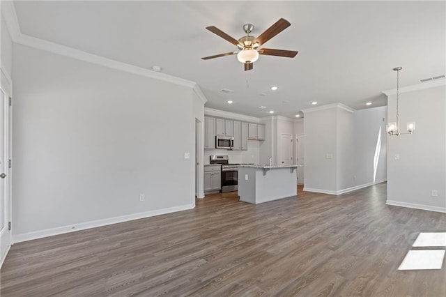 unfurnished living room with baseboards, recessed lighting, ceiling fan with notable chandelier, wood finished floors, and crown molding