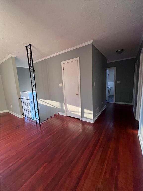 unfurnished room featuring crown molding, dark hardwood / wood-style flooring, and a textured ceiling