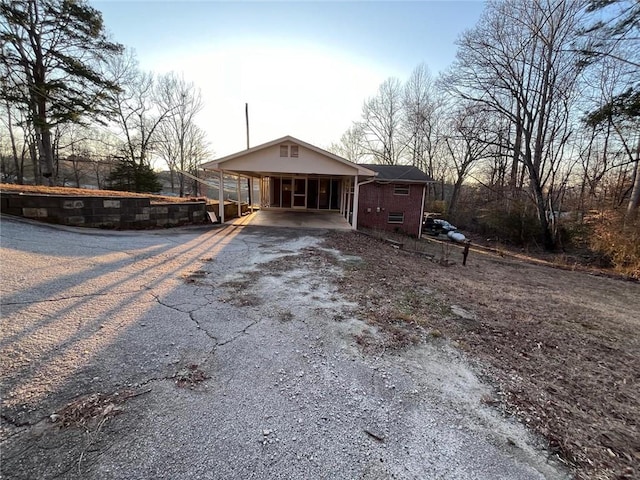 back house at dusk featuring a carport