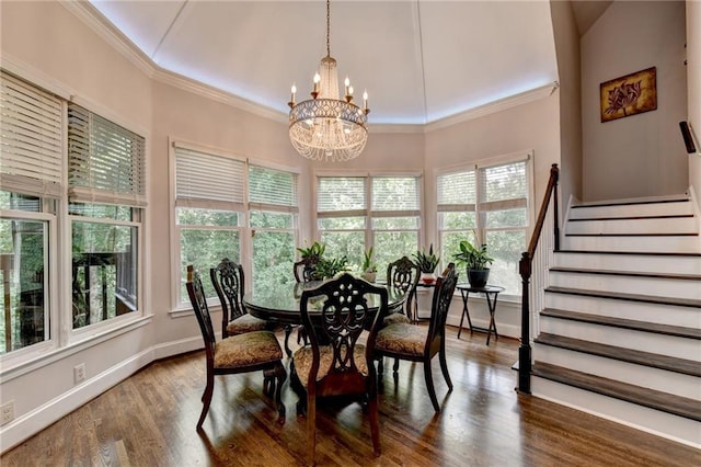 dining area featuring a chandelier, wood finished floors, baseboards, stairway, and crown molding