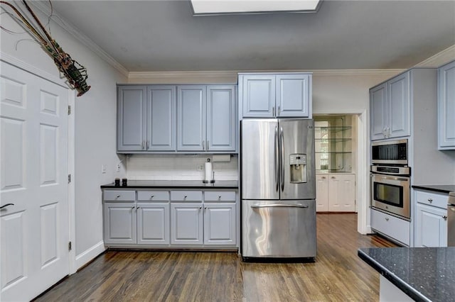 kitchen featuring stainless steel appliances, dark wood finished floors, crown molding, and tasteful backsplash