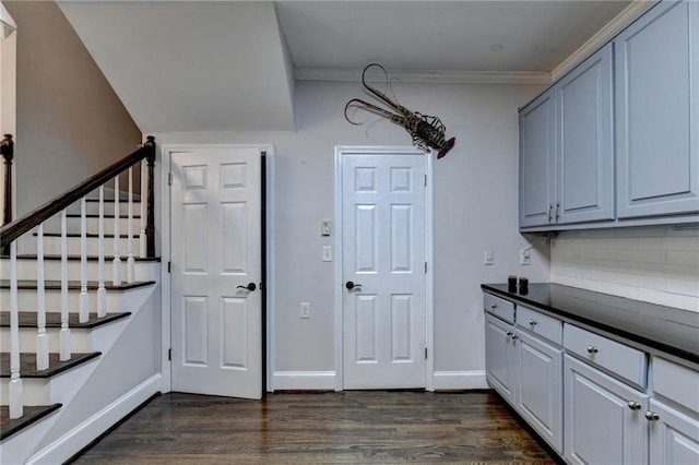 interior space featuring ornamental molding, dark wood-type flooring, and baseboards