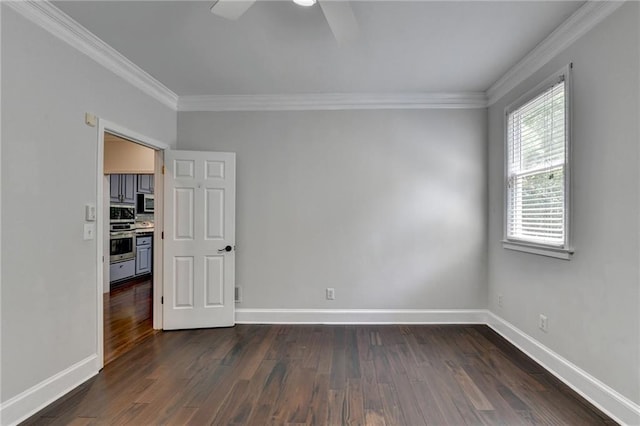 unfurnished room featuring dark wood-style floors, ornamental molding, and baseboards