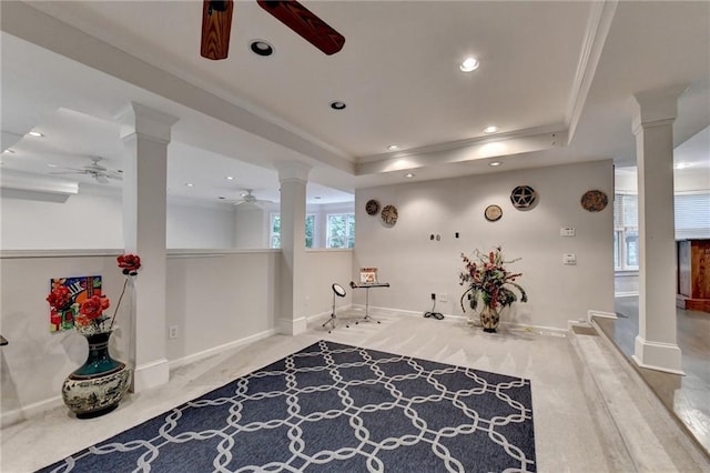 interior space featuring ornamental molding, a tray ceiling, and decorative columns