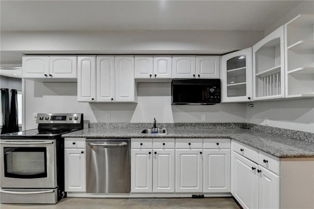 kitchen with glass insert cabinets, white cabinetry, stainless steel appliances, and a sink