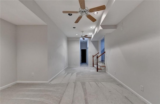 unfurnished living room with recessed lighting, light colored carpet, stairway, a ceiling fan, and baseboards