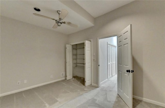 unfurnished bedroom with baseboards, ceiling fan, a closet, and light colored carpet