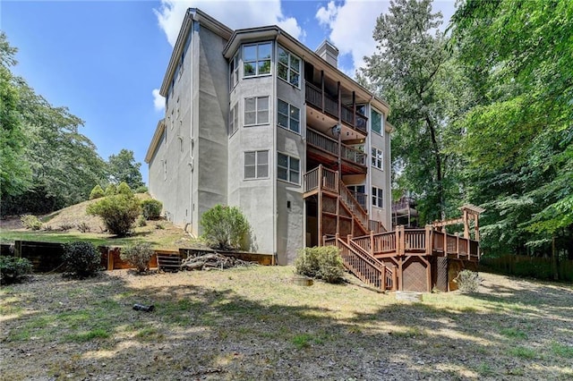 exterior space with a deck, a chimney, and stairway