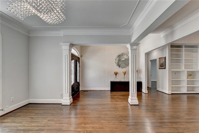 spare room with crown molding, decorative columns, baseboards, and wood finished floors