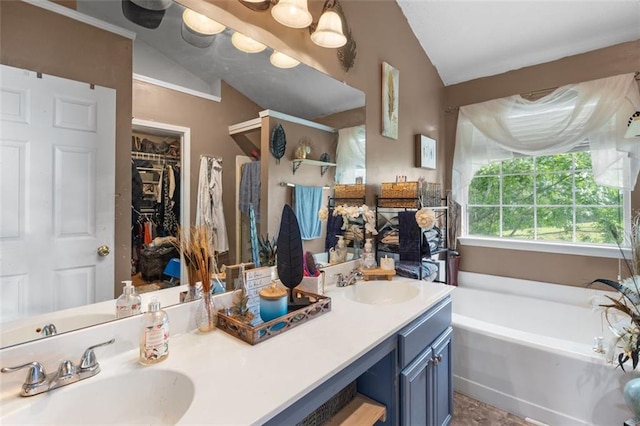 5077 Newpark Dr NW, Acworth, GA 30101 - bathroom with double vanity, a bath, vaulted ceiling, and a sink