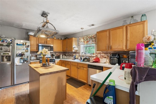 5077 Newpark Dr NW, Acworth, GA 30101 - kitchen with butcher block countertops, tasteful backsplash, visible vents, light wood finished floors, and appliances with stainless steel finishes