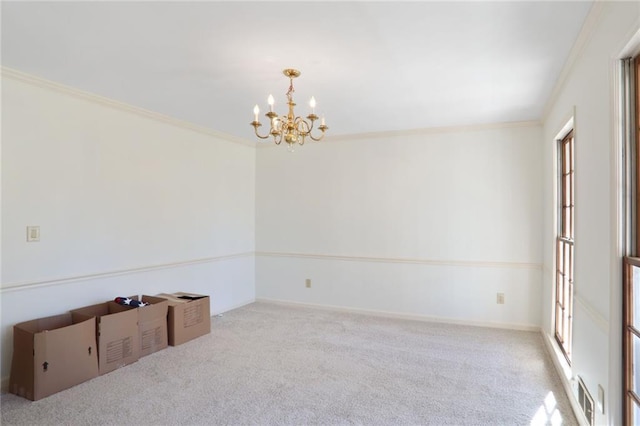 carpeted empty room featuring an inviting chandelier, baseboards, visible vents, and crown molding