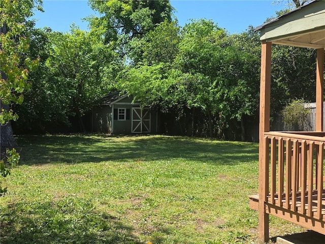 view of yard featuring an outdoor structure, a shed, and a deck