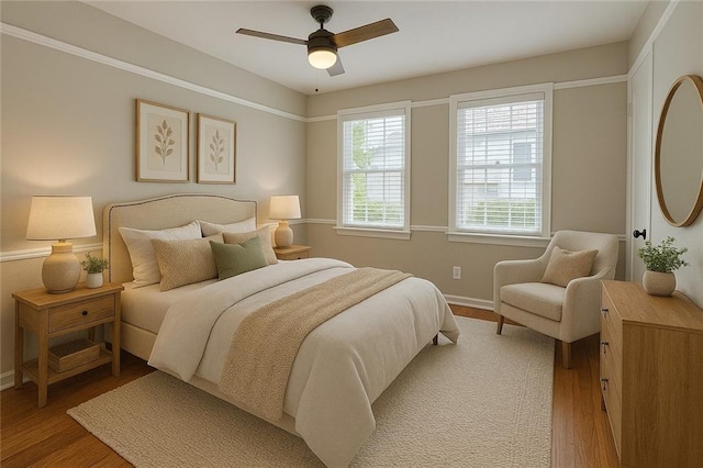 bedroom featuring a ceiling fan, baseboards, and light wood-type flooring