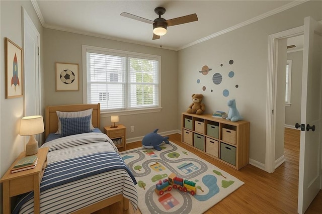 bedroom with ornamental molding, ceiling fan, baseboards, and light wood-style floors