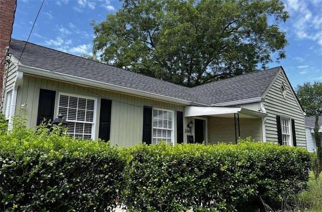 view of side of home with a chimney and a shingled roof