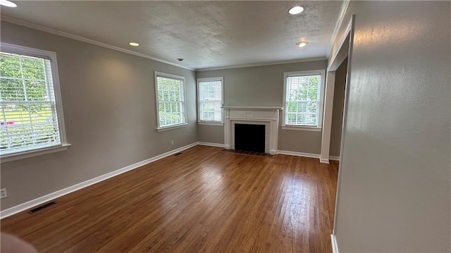 unfurnished living room with ornamental molding, dark wood-style flooring, a brick fireplace, and a wealth of natural light