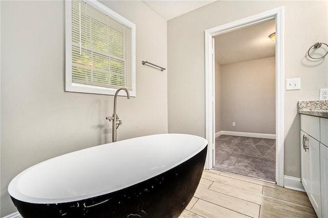 bathroom with hardwood / wood-style floors, a bathtub, and vanity