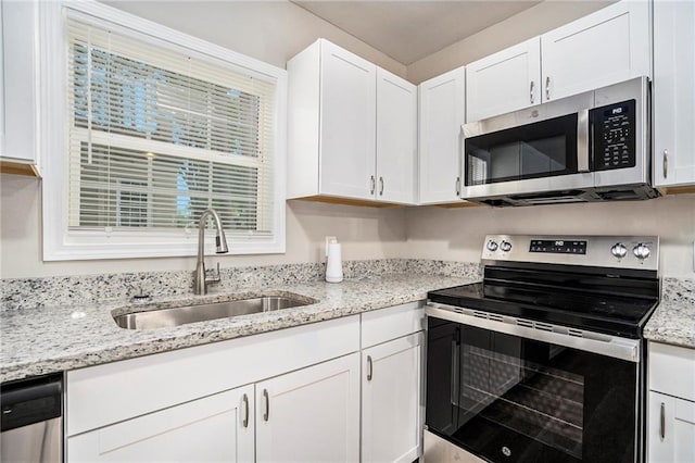 kitchen featuring light stone countertops, sink, white cabinetry, and stainless steel appliances