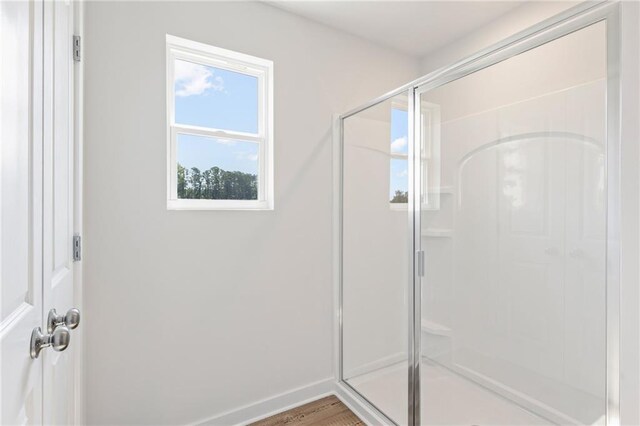 bathroom featuring a shower stall and baseboards