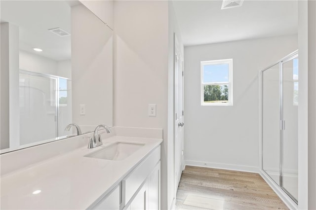 full bathroom with visible vents, a stall shower, wood finished floors, and vanity